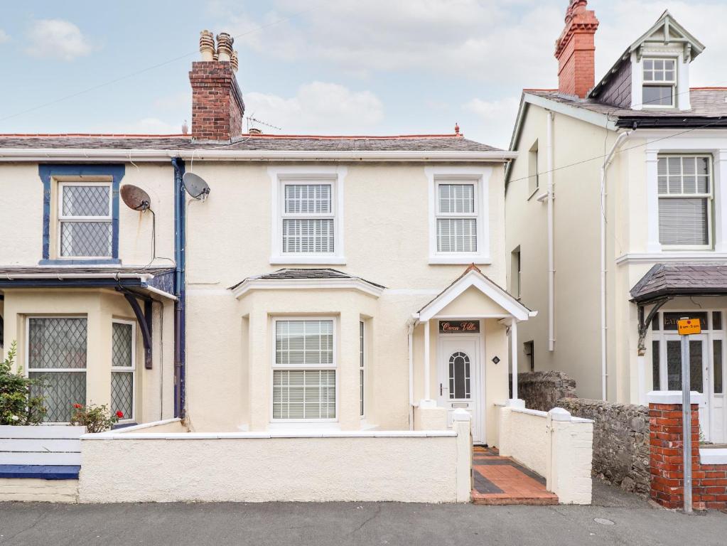 una casa blanca con una valla delante en Owen Villa, en Llandudno