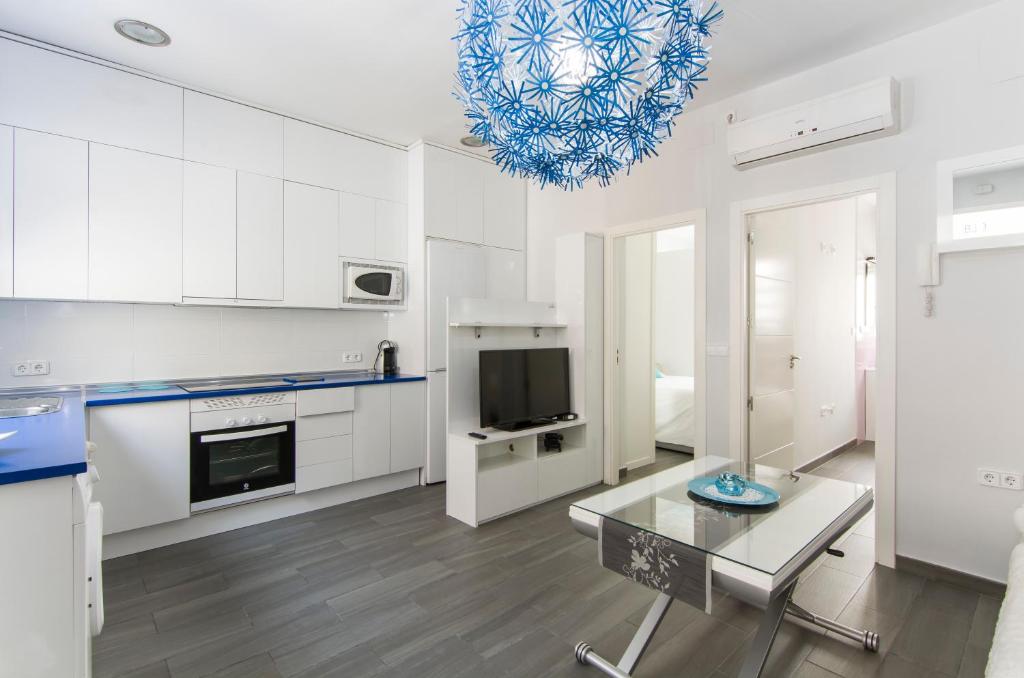 a kitchen with white cabinets and a blue chandelier at FANTÁSTICO APARTAMENTO MADRID RIÓ-PUERTA DEL ÁNGEL in Madrid