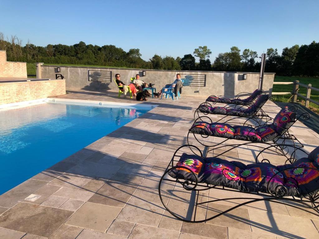 - une paire de chaises à côté de la piscine dans l'établissement Domaine de la Bellière, à Villars-les-Dombes