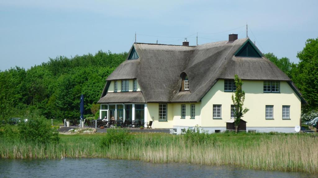 a large white house with a thatched roof at Golfcentrum Schloss Karnitz Rügen in Garz