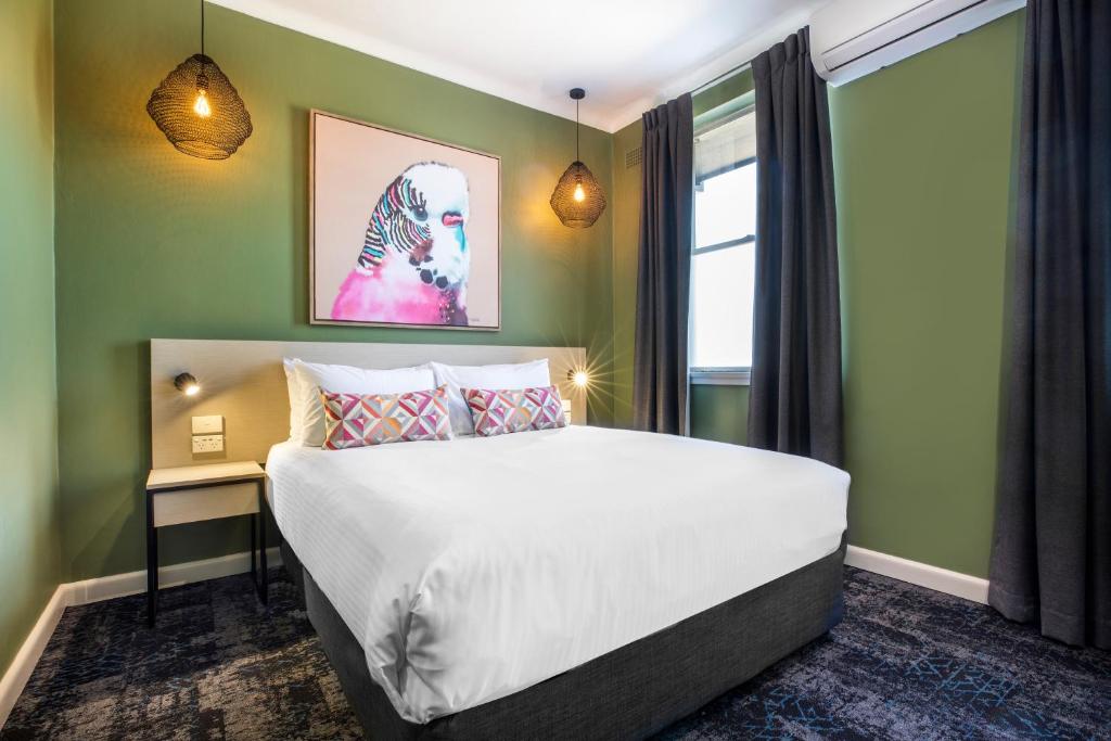 a bedroom with a large bed and a window at Nightcap at Pritchards Hotel in Mount Pritchard