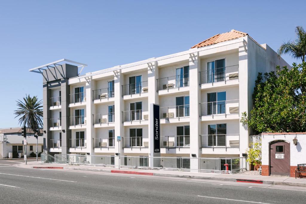 een wit gebouw aan de straatkant bij Sonder Solarena in Newport Beach