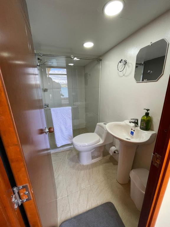 een badkamer met een douche, een toilet en een wastafel bij La Puerta Del Lago ECOPARQUE in Tota