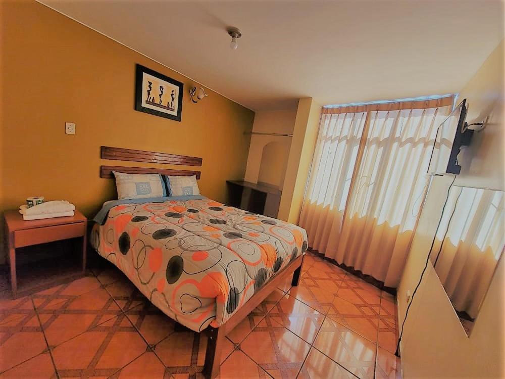 1 dormitorio con cama, mesa y ventana en Hostal Cristal de luna, en Arequipa