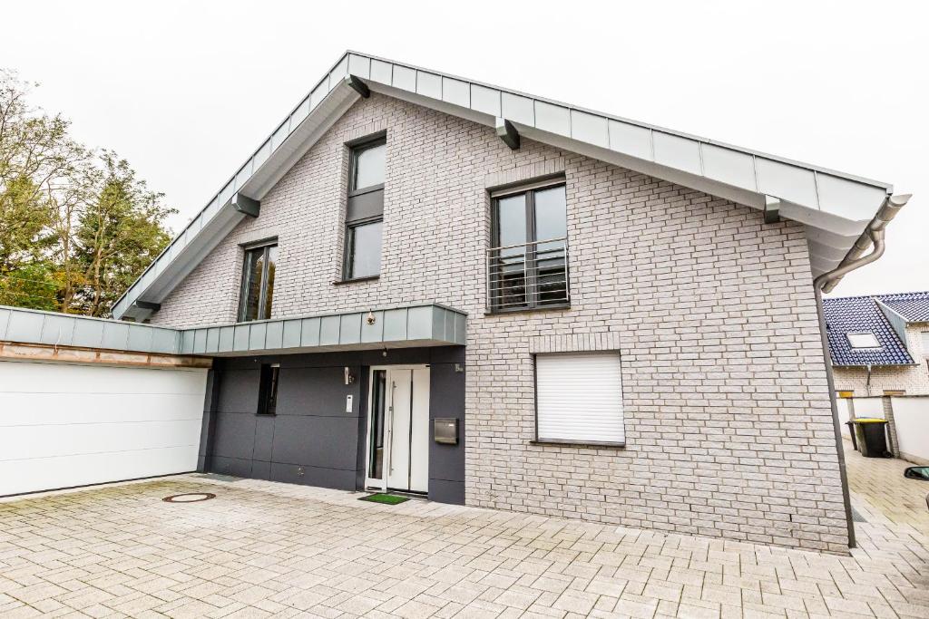 een wit bakstenen huis met een garage bij Komfort Design Wohnung Köln in Keulen