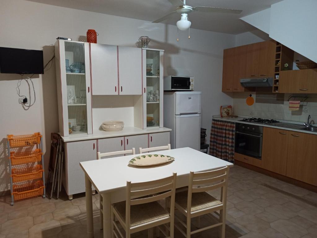 une cuisine avec une table blanche et quelques placards dans l'établissement Casa Gialla, à Torre Pali