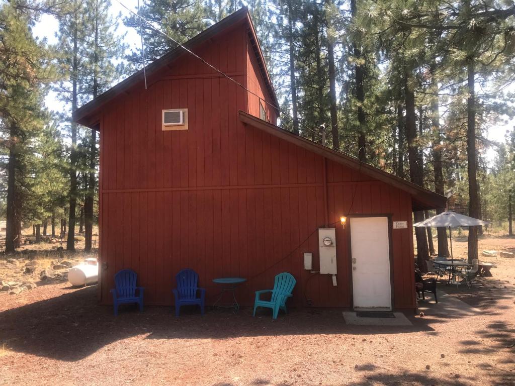eine rote Scheune mit blauen Stühlen davor in der Unterkunft Cheerful 2-Bedroom Cottage Near Eagle Lake in Susanville