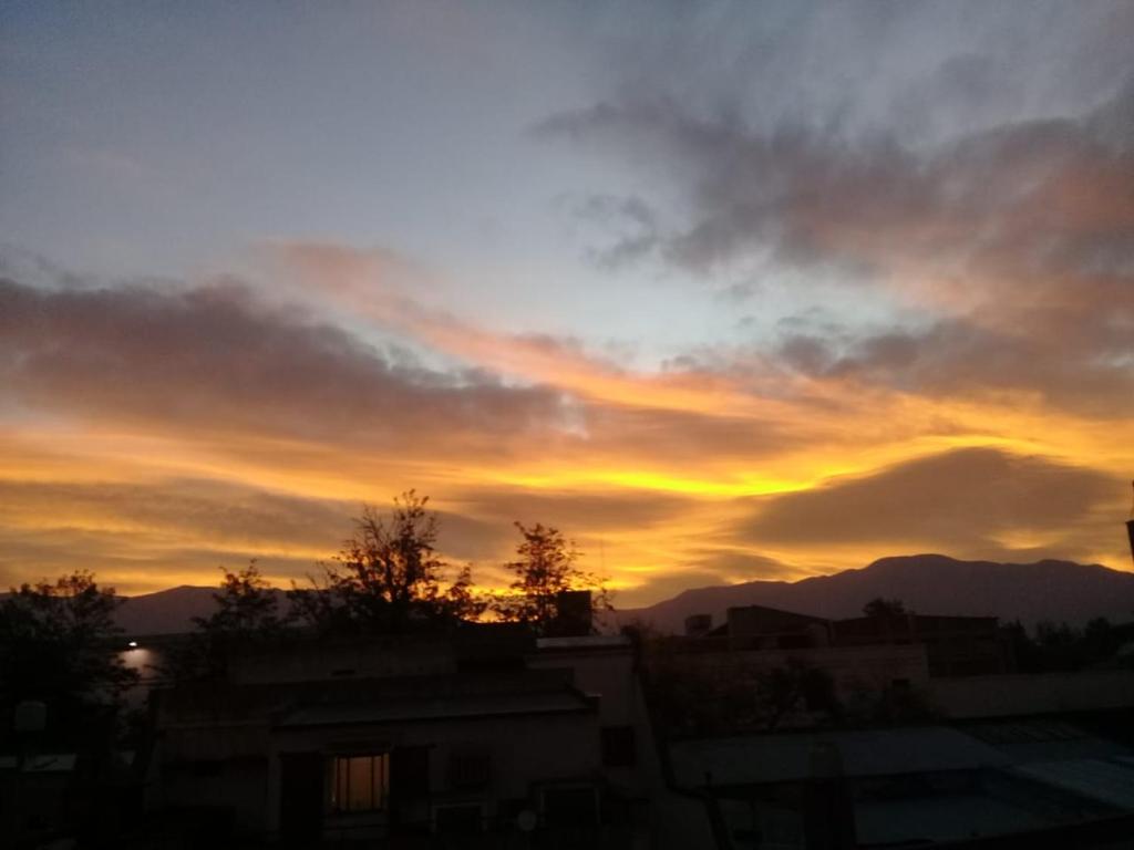 a sunset in the sky with mountains in the background at HOSTEL JUJUY in San Salvador de Jujuy