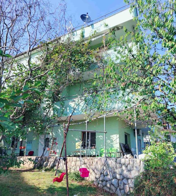 a green house with a stone wall at Green house in Čavle