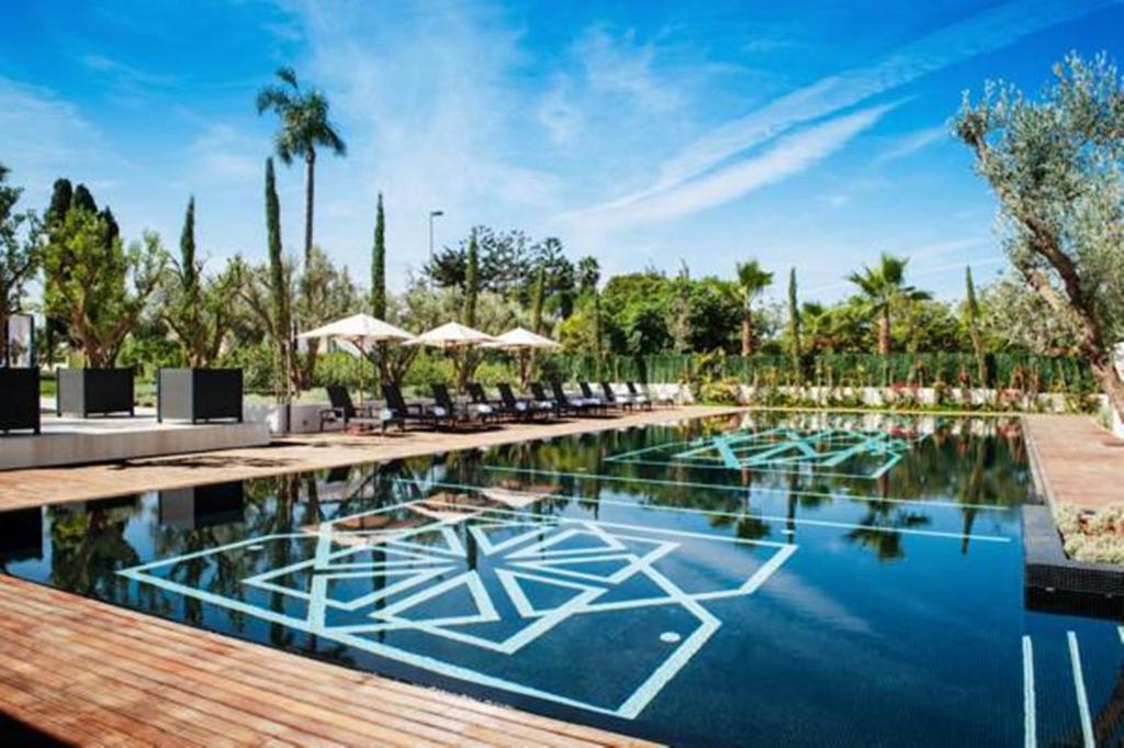 uma piscina com cadeiras e guarda-sóis num resort em STORY Rabat em Rabat