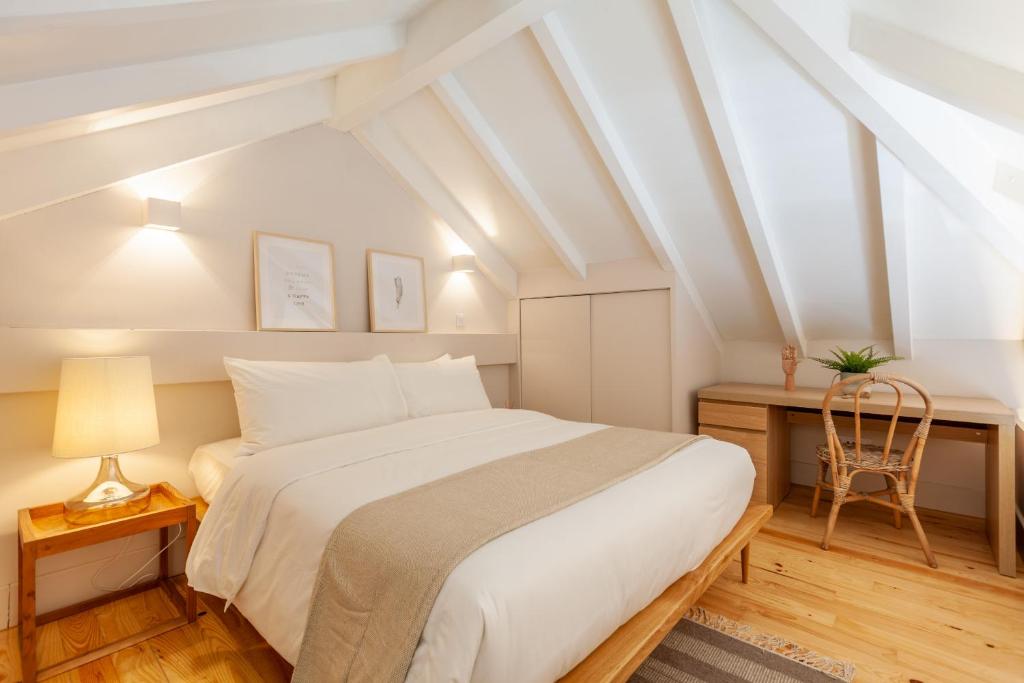a bedroom with a bed and a desk with a chair at D&S - JB Apartments in Porto