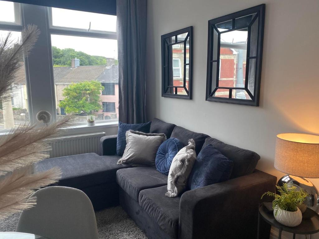a cat sitting on a couch in a living room at The Retreats 2 Kenfig Hill Pet Friendly 2 Bedroom Flat with King Size bed twin beds and sofa bed sleeps up to 5 people in Kenfig Hill