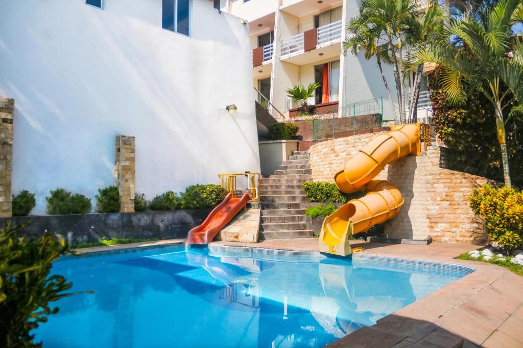 a swimming pool with a slide in a resort at VF Villa Florencia Hotel in Veracruz