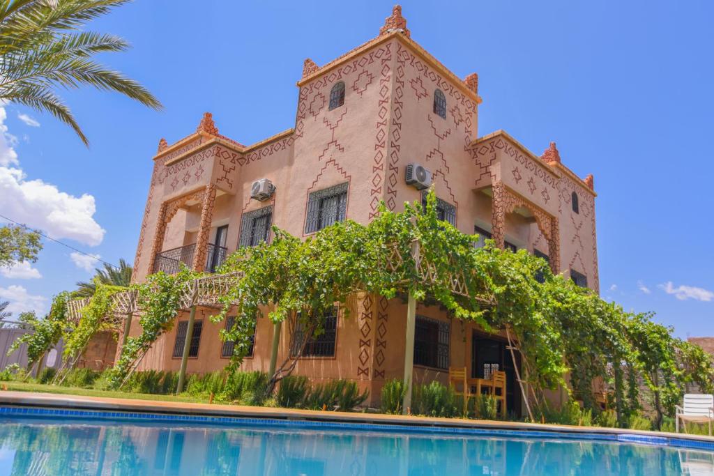 um edifício com uma piscina em frente em Kasbah Roseville em Aït Ouahi