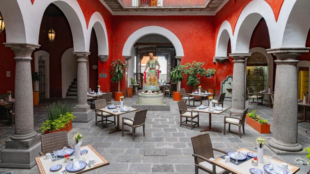 a restaurant with tables and chairs and a fountain at Hotel Boutique Casona de la China Poblana - Adults Only in Puebla