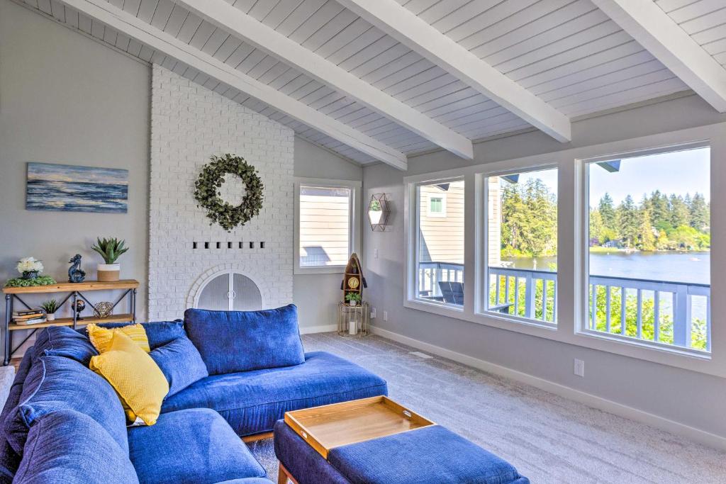 a living room with a blue couch and windows at Lakeside Lacey Gem w/ Sauna + Private Dock in Lacey