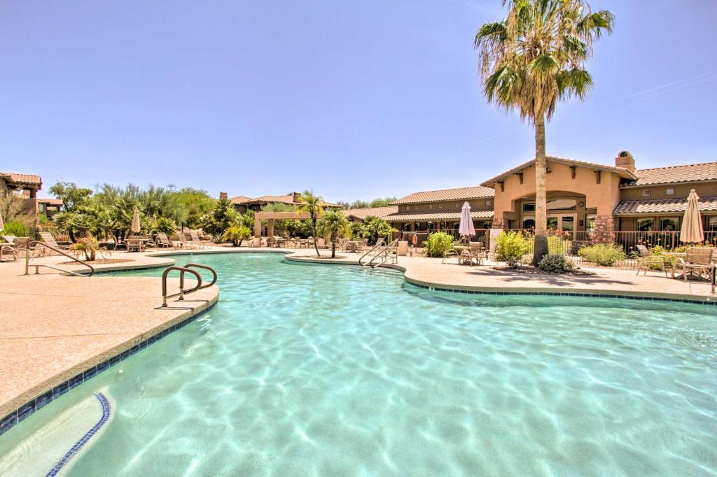 a swimming pool at a resort with a palm tree at Comfy Scottsdale Condo with Resort Amenities! in Scottsdale