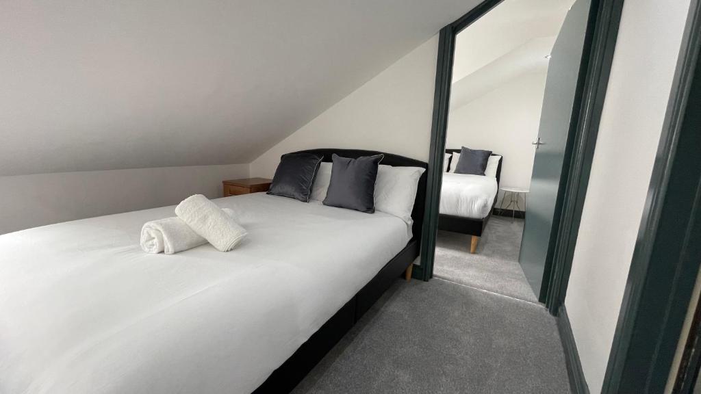 um quarto com uma grande cama branca e 2 almofadas em Lovely 2 Bed Apartment by YO ROOM- Leicester City- Free Parking em Leicester