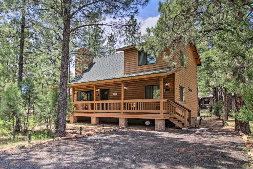 a log home with a large deck in the woods at 2 Mi to Fool Hollow Lake Wooded Cabin with Fire Pit in Show Low