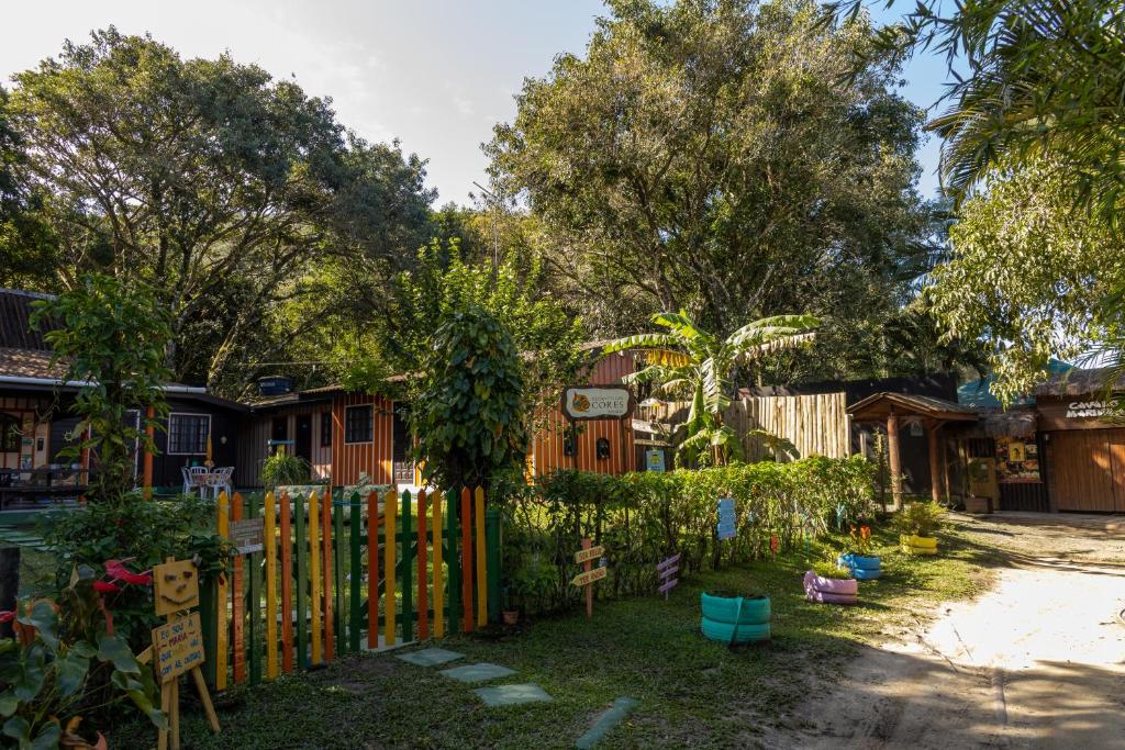 a yard with a wooden fence and a house at Pousada Recanto das Cores in Ilha do Mel