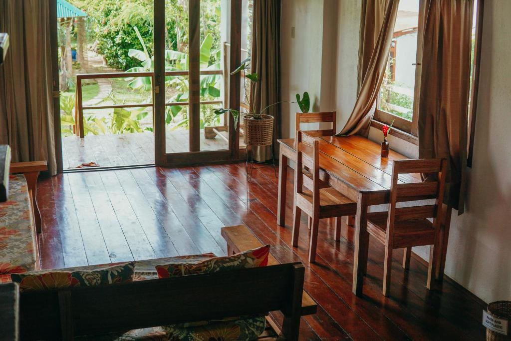 a living room with a wooden table and chairs at Ferra Resort Siargao in General Luna