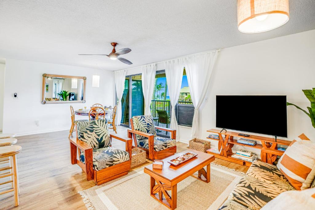 sala de estar con TV de pantalla plana y muebles en Kauai Beach Villas E5, en Lihue