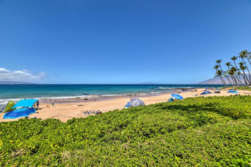a beach with a bunch of umbrellas and the ocean at Gorgeous Oceanfront Kihei Condo w/ Balcony! in Wailea