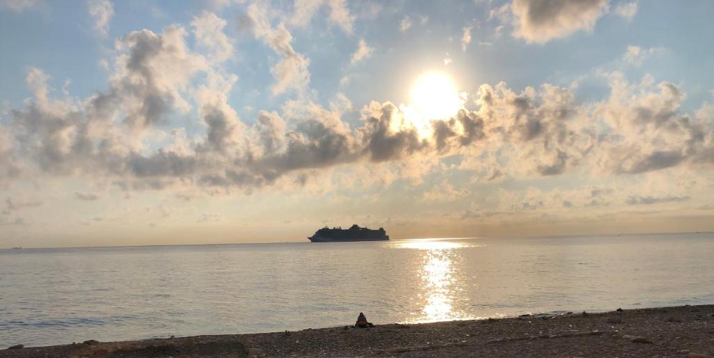 a person sitting on the beach in front of the ocean at IL PROFUMO DEL MARE in Palermo