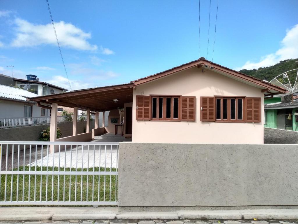ein kleines Haus mit einem Zaun davor in der Unterkunft Casa na Pinheira, Praia de Cima in Pinheira