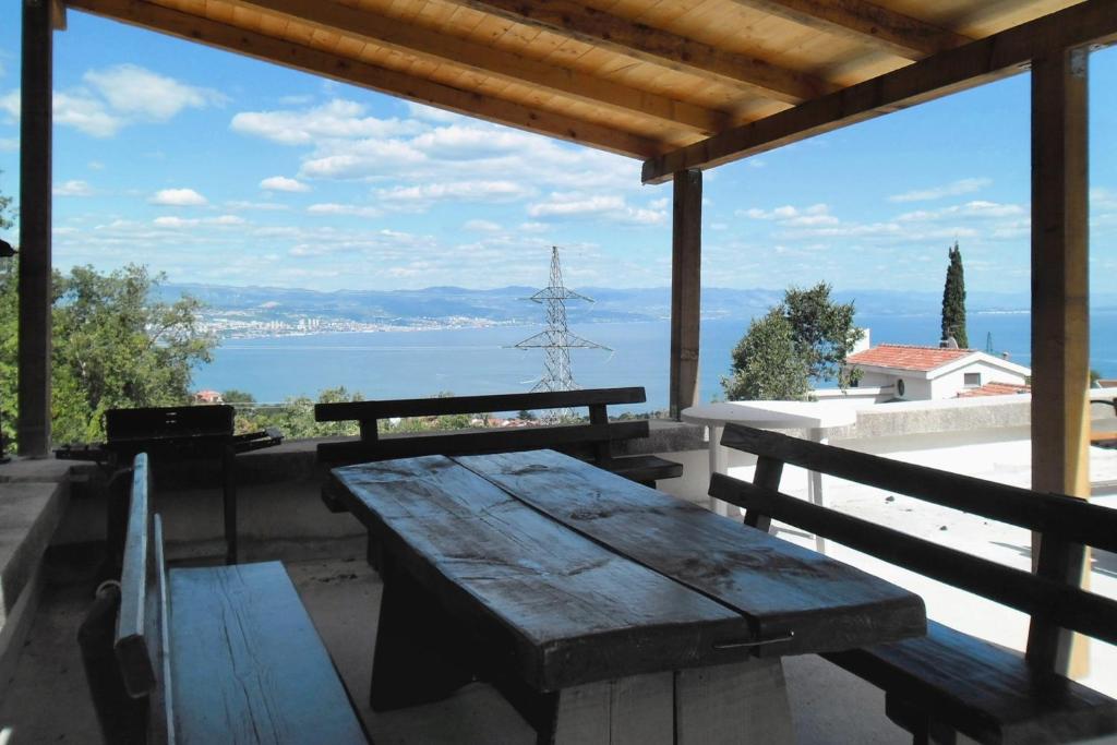 a picnic table on a porch with a view of the water at Apartments with WiFi Opric, Opatija - 7756 in Lovran