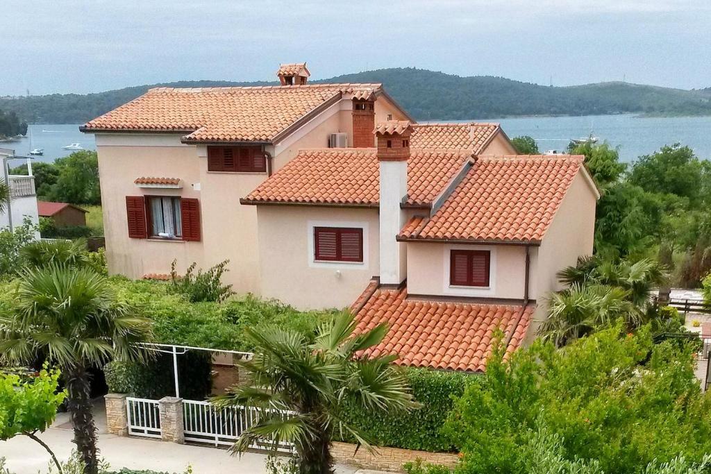 a house with red tile roofs and the water at Apartments with parking space Medulin - 7657 in Medulin