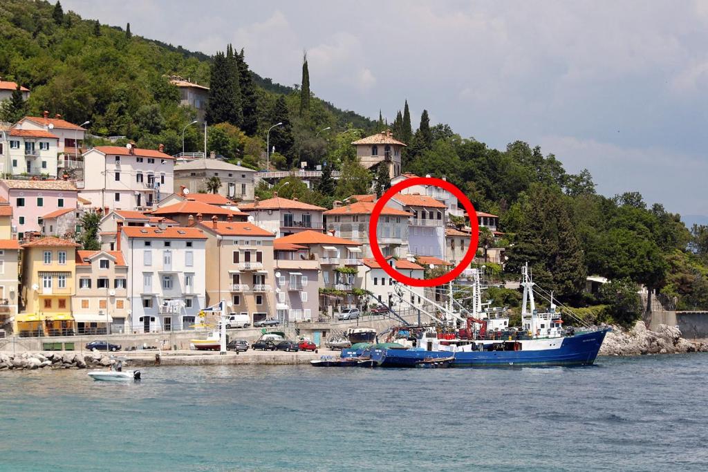 un barco en el agua con un círculo rojo en Rooms by the sea Moscenicka Draga, Opatija - 7767, en Mošćenička Draga