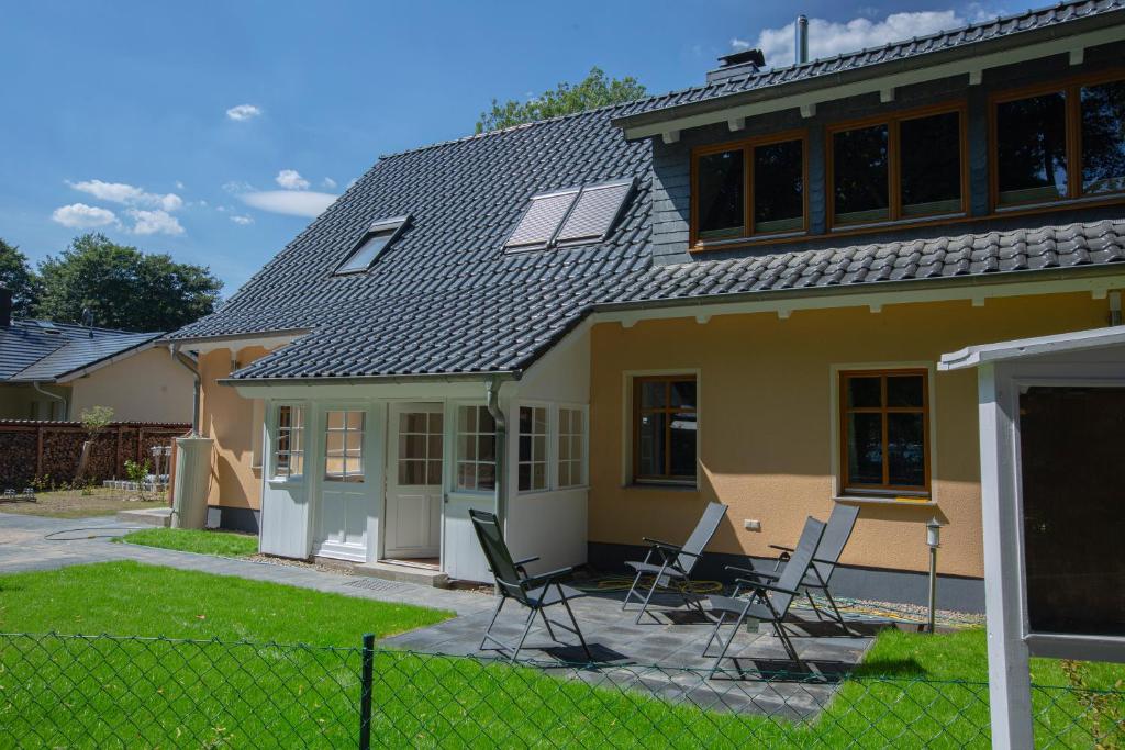 una casa con sillas sentadas en el patio en Ferienwohnungen Wildau am Werbellinsee, en Schorfheide
