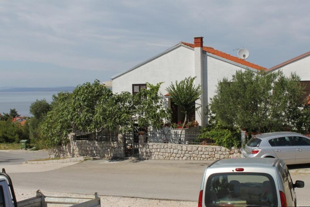a car parked in front of a white house at Apartments with a parking space Mali Losinj (Losinj) - 7969 in Mali Lošinj