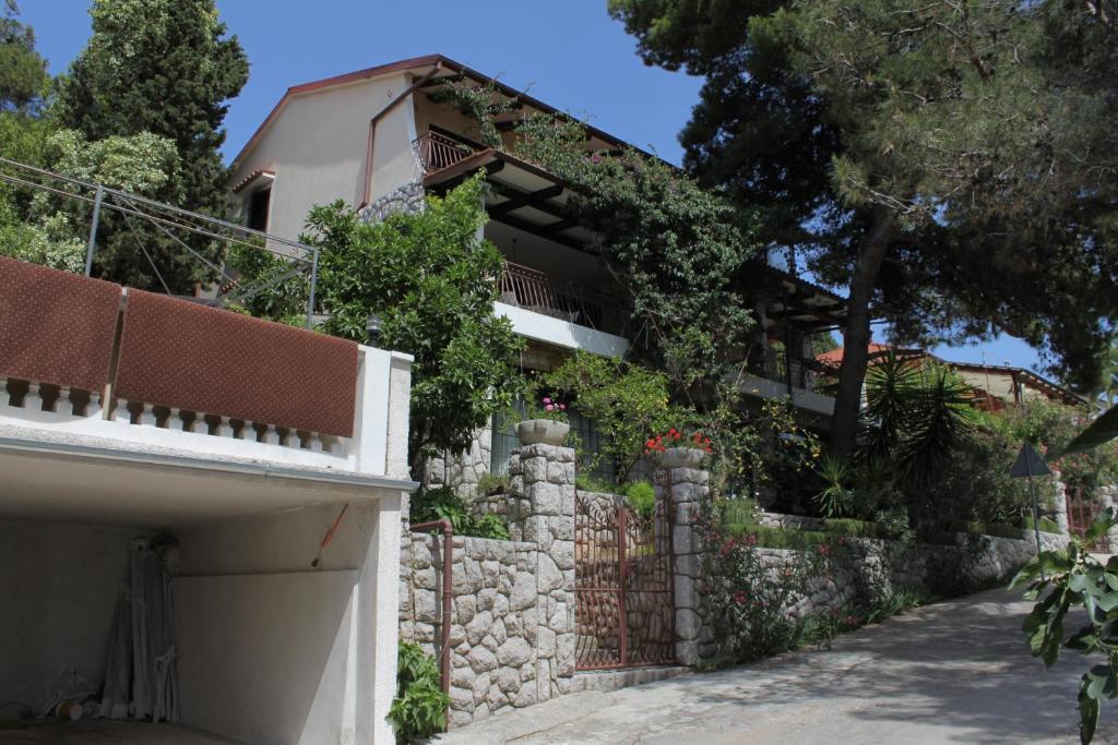 a house with a stone wall and a driveway at Apartments with WiFi Mali Losinj (Losinj) - 7992 in Mali Lošinj