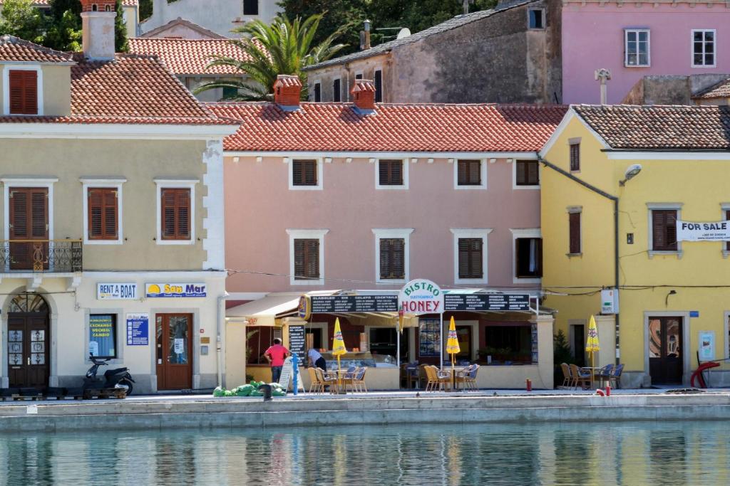 a group of buildings next to a body of water at Apartments by the sea Mali Losinj (Losinj) - 8001 in Mali Lošinj