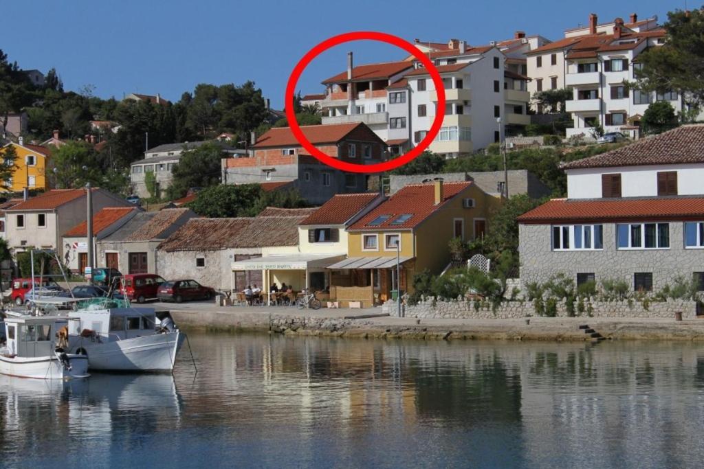 a red circle is sitting on top of a river at Apartments and rooms by the sea Mali Losinj (Losinj) - 7977 in Mali Lošinj