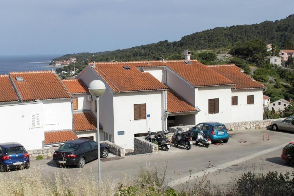 a group of buildings with cars parked in a parking lot at Apartments with a parking space Mali Losinj (Losinj) - 7998 in Mali Lošinj