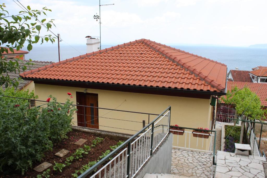 a house with a red roof and a fence at Apartments with a parking space Icici, Opatija - 7788 in Ičići