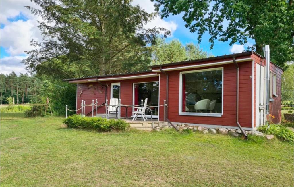 a red tiny house with a porch and a yard at Lovely Home In Ot Goritz -wardow With Kitchen 