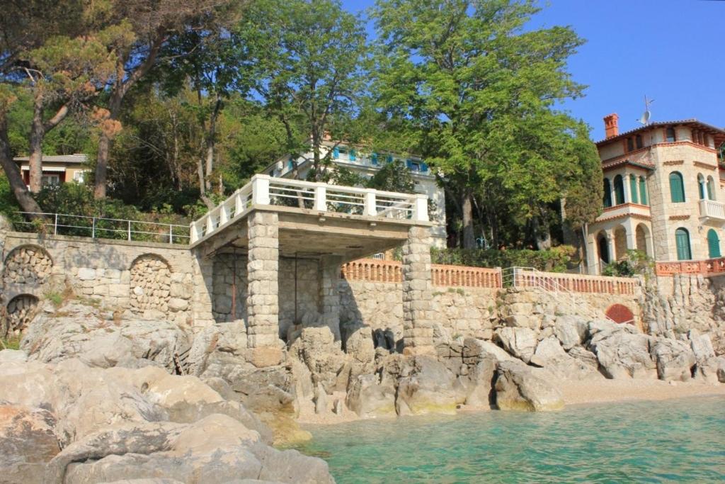 a bridge over a body of water next to a building at Family friendly seaside apartments Moscenicka Draga, Opatija - 7798 in Mošćenička Draga