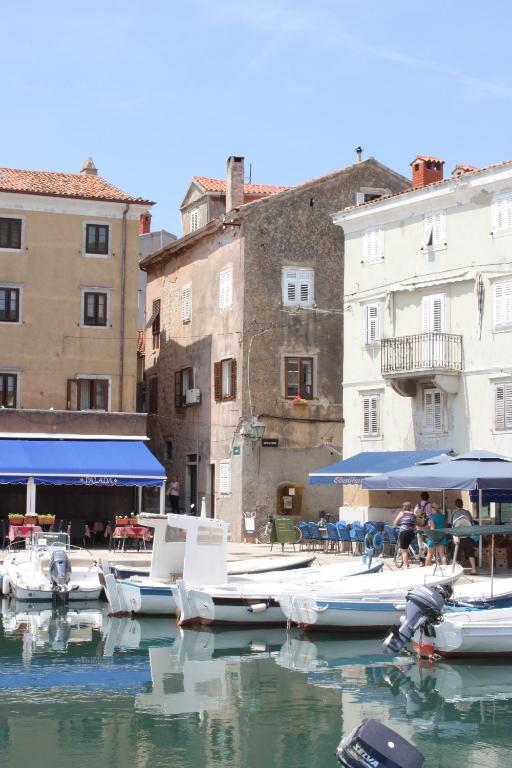 a group of boats docked in a harbor with buildings at Apartments by the sea Cres - 7875 in Cres
