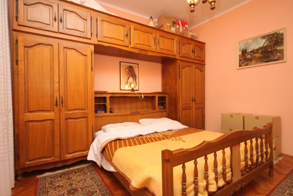 a bedroom with a bed and a large wooden cabinet at Apartments by the sea Cres - 7875 in Cres