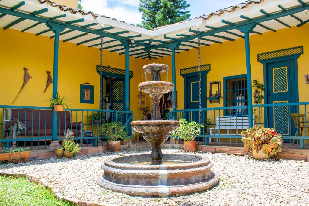 a fountain in the courtyard of a yellow building at FINCA COCUYAL...todo un pesebre VIVO! in Rionegro