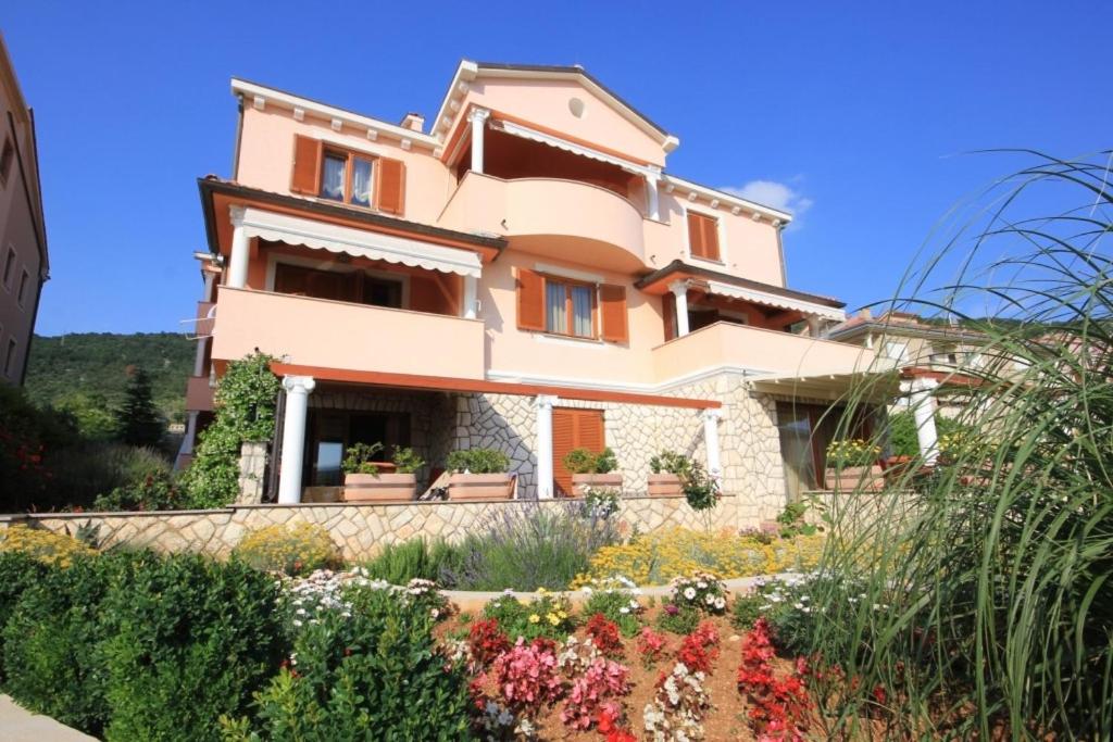 a house with a garden in front of it at Apartments with a parking space Cres - 7985 in Cres