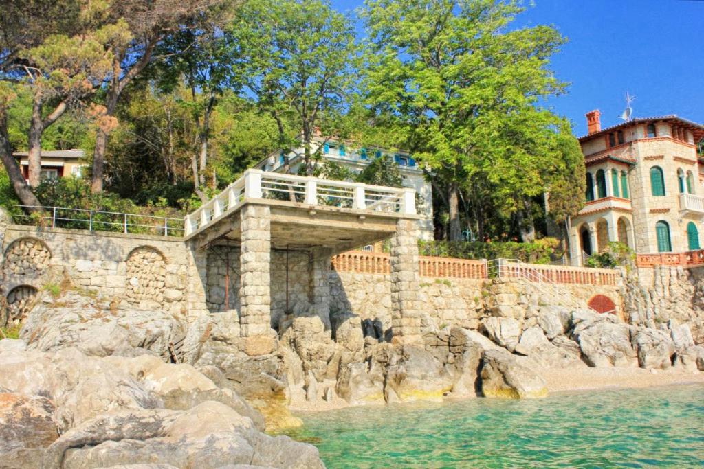 a bridge over a body of water next to a building at Family friendly seaside apartments Moscenicka Draga, Opatija - 9242 in Mošćenička Draga