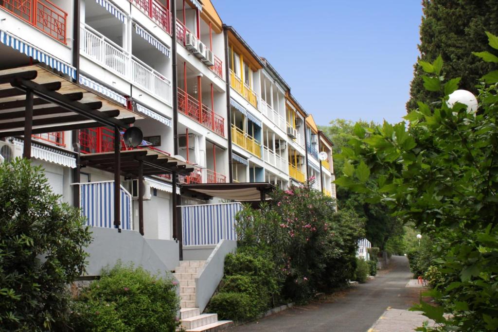 Apartments with a parking space Icici, Opatija - 7859 في إيتْشيتْشي: مبنى شقق بشرفات على شارع