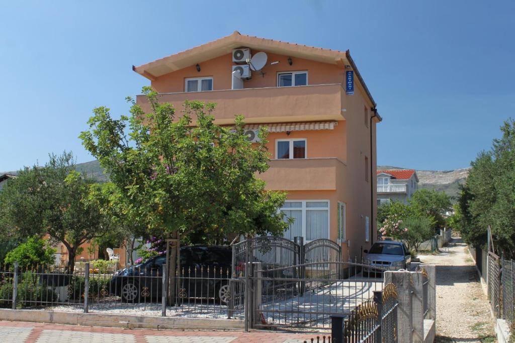 un bâtiment avec une clôture devant lui dans l'établissement Apartments for families with children Kastel Stafilic, Kastela - 9211, à Kaštela