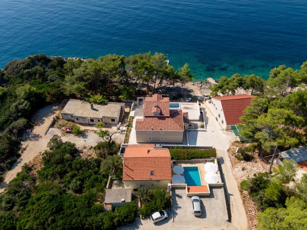 an aerial view of a house with the ocean at Seaside family friendly house with a swimming pool Brna - Vinacac, Korcula - 9266 in Prizba
