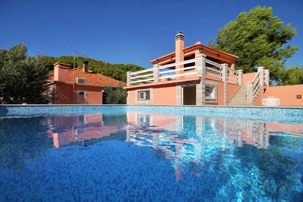 a swimming pool with a house in the background at Family friendly apartments with a swimming pool Smokvica, Korcula - 9161 in Smokvica